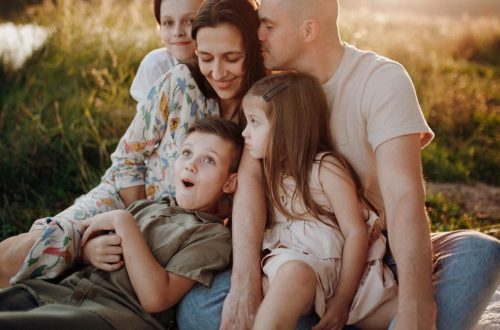 A joyful family enjoying quality time together on a sunset-lit meadow.