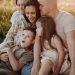 A joyful family enjoying quality time together on a sunset-lit meadow.